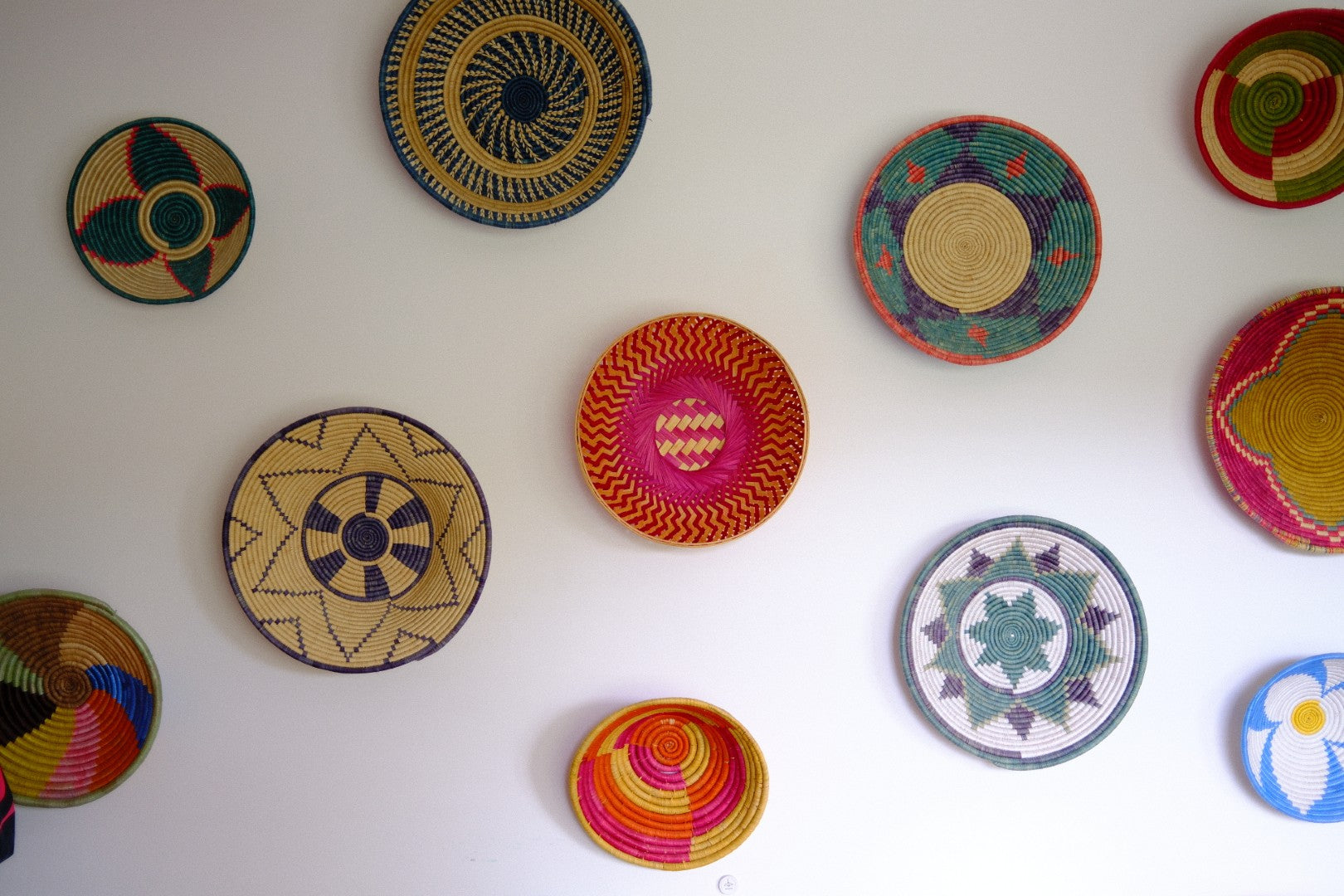 Colorful woven baskets on a white wall
