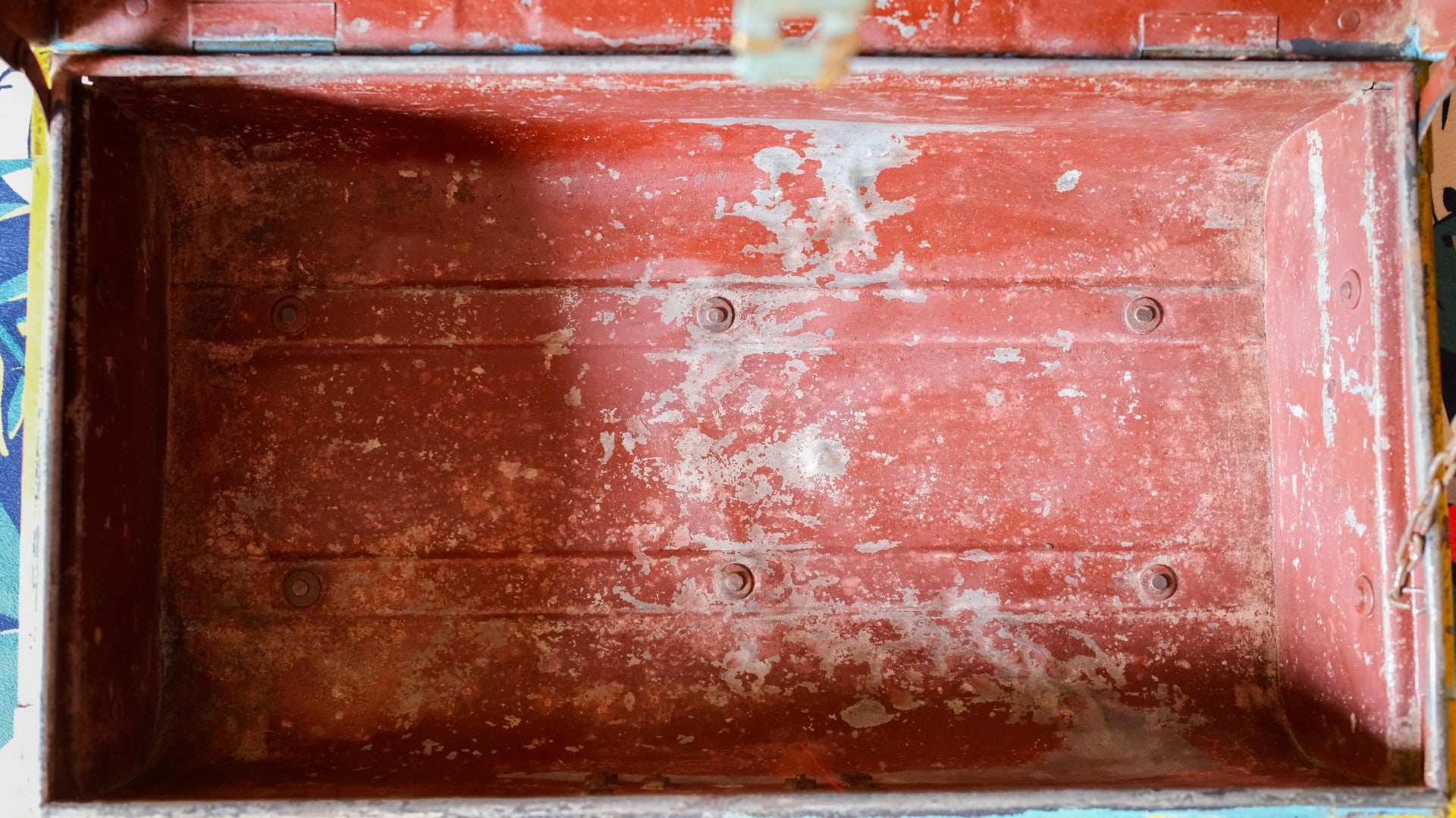 Close-up of metal trunk with visible wear and tear