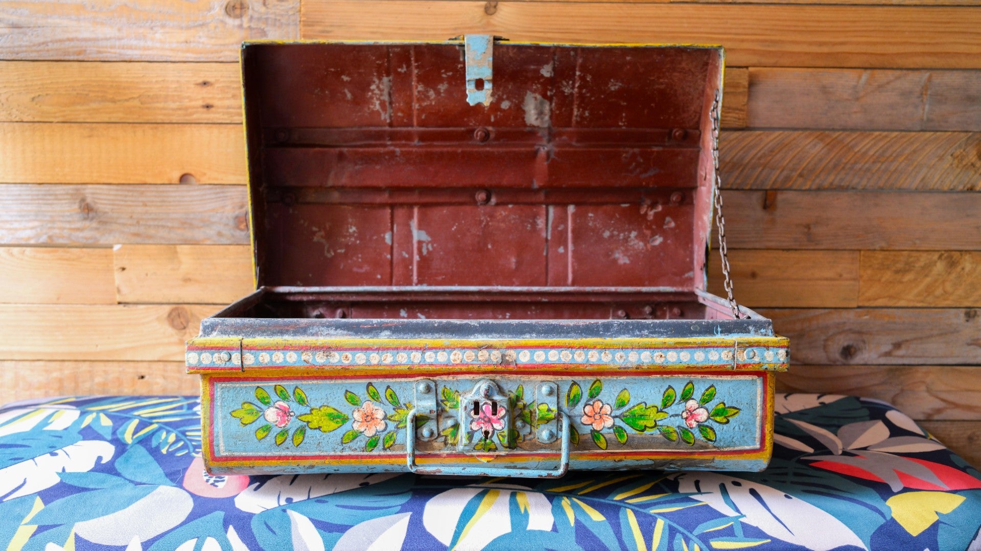 Decorative metal trunk with floral patterns on a colorful fabric background