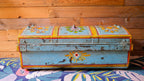 Vintage trunk with floral designs on a wooden floor