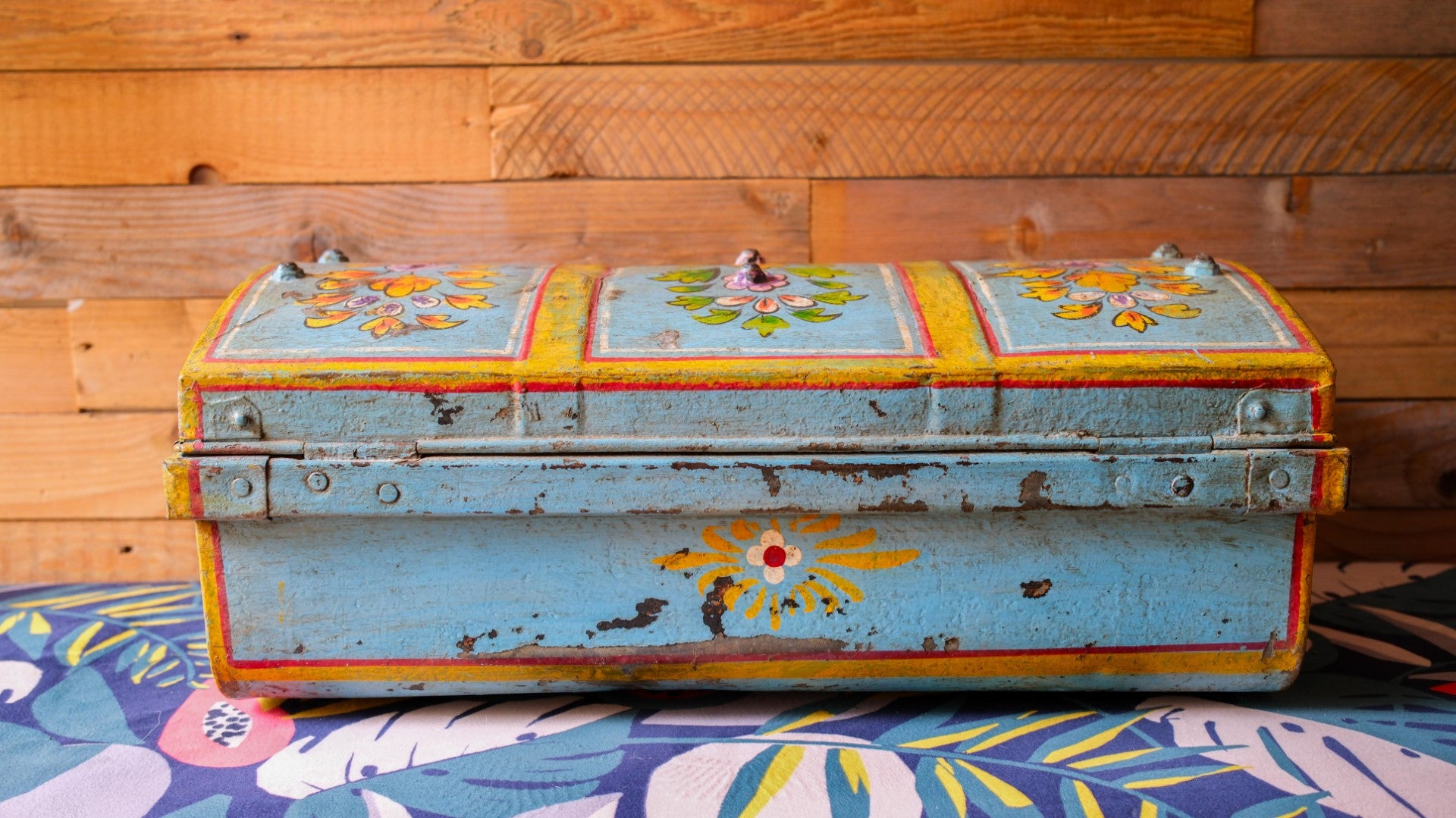 Vintage trunk with floral designs on a wooden floor