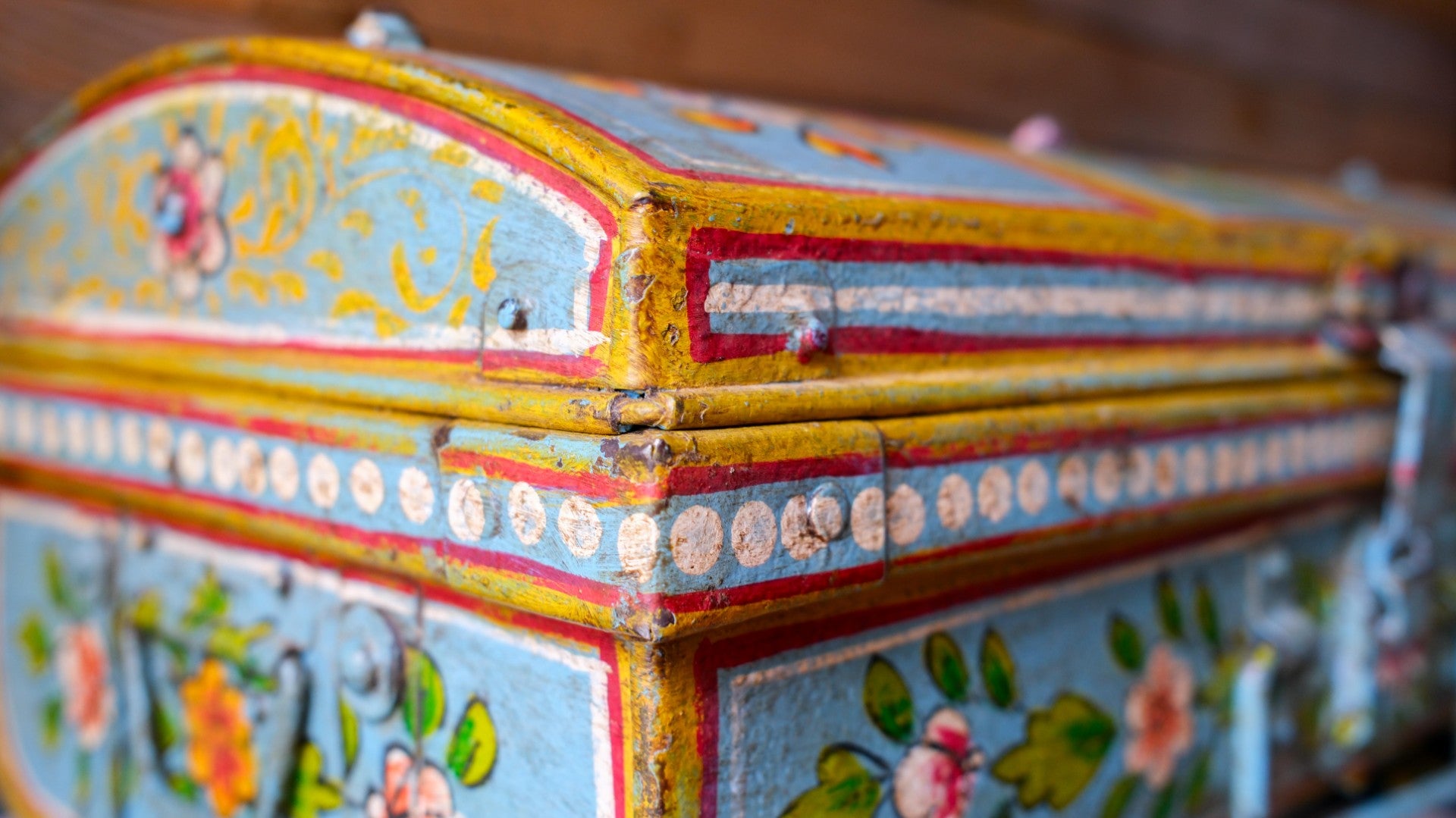 Decorative metal trunk with colorful floral patterns on a blurred background