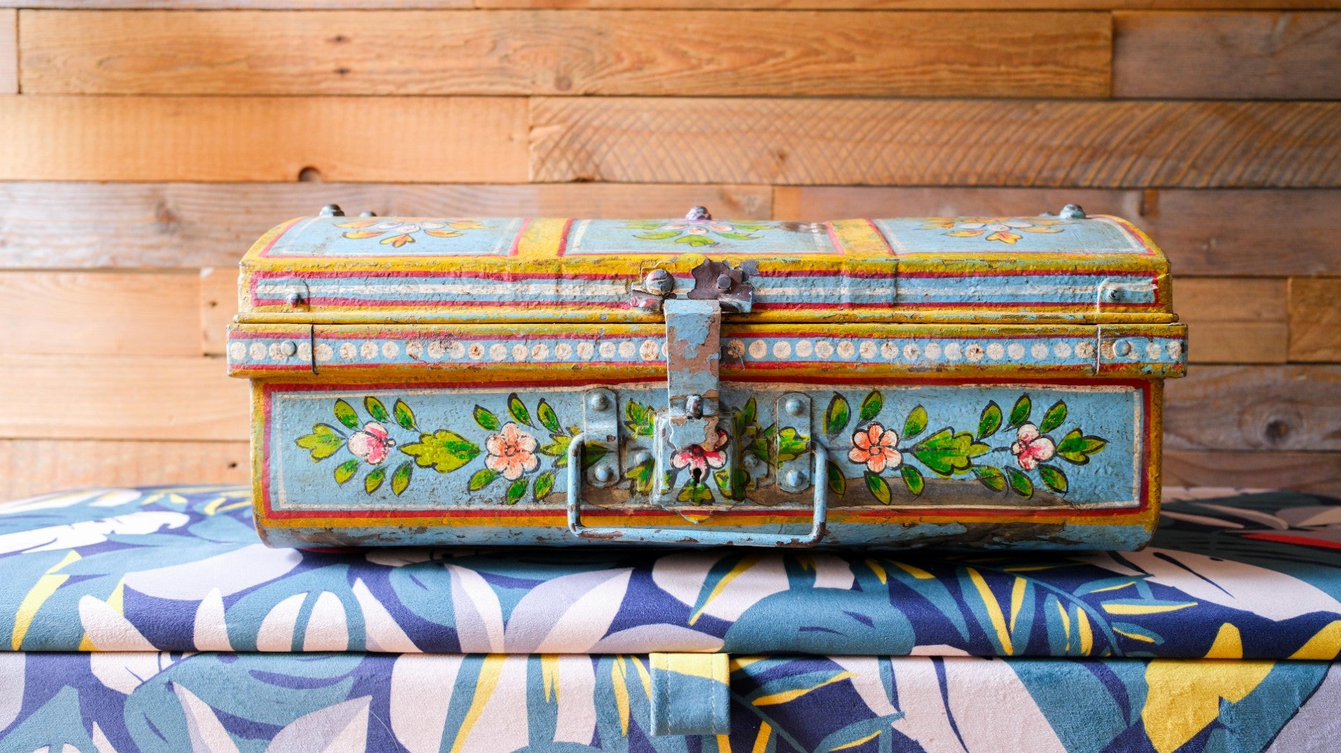 Decorative wooden chest with floral patterns on a wooden surface