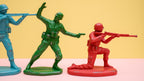 Three toy soldiers in action poses on a pink and yellow background