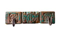 Decorative metal wall hook with floral designs on a colorful fabric background