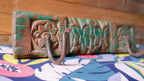 Decorative wooden block with intricate carvings on a colorful fabric background