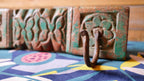 Decorative metal hook on a colorful fabric background