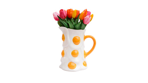 Fried egg jug with colorful tulips on a white background