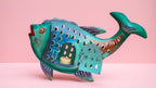 Decorative fish-shaped candle holder on a pink background