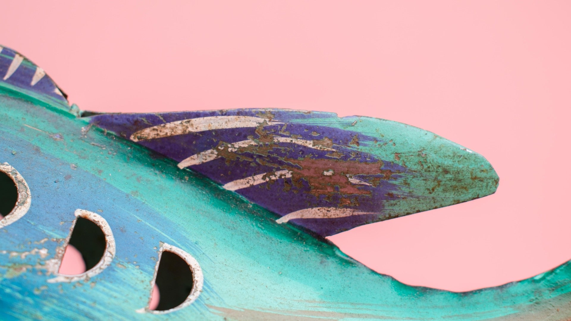 Decorative fish-shaped birdhouse with a pink background