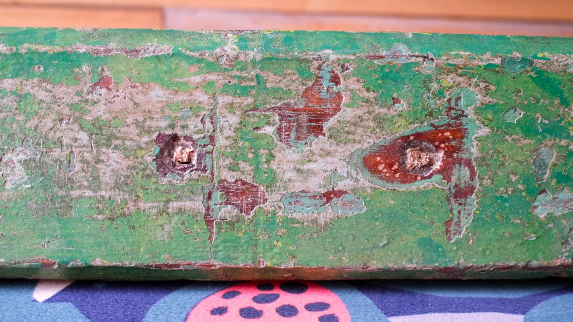 Rust and peeling paint on a green metal surface