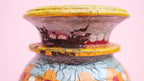 Decorative vase with colorful patterns on a pink background