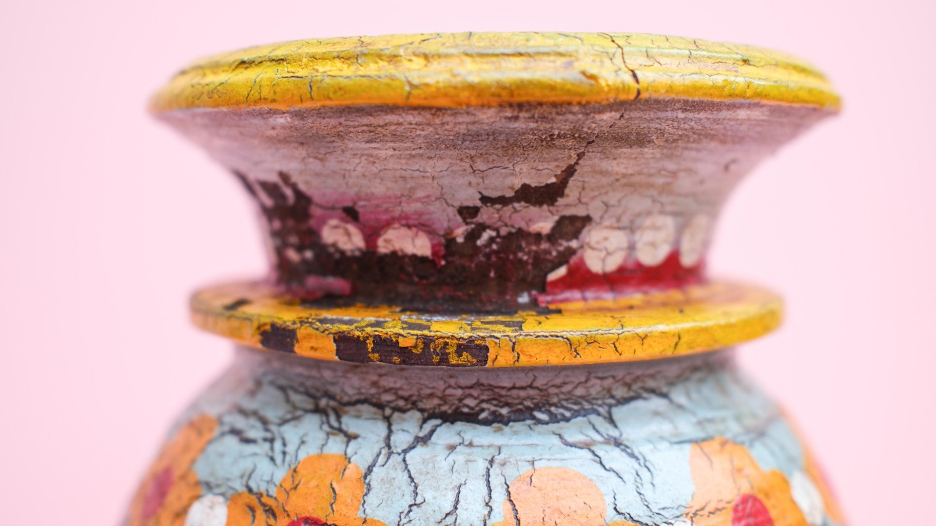 Decorative vase with colorful patterns on a pink background