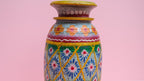 Decorative vase with colorful patterns on a pink background