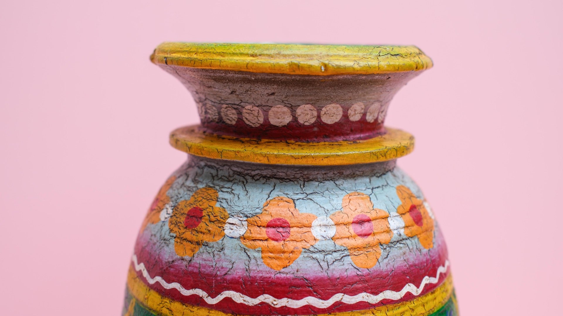 Decorative pot with colorful patterns on a pink background