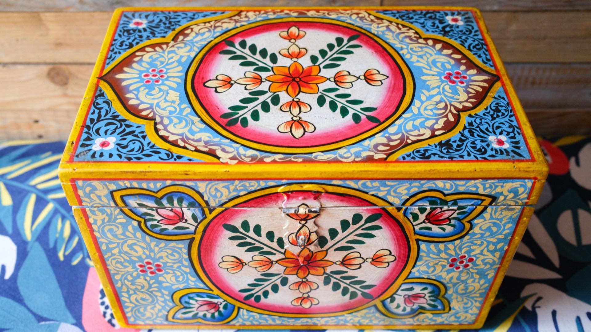 Decorative box with floral patterns on a wooden surface