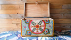 Wooden box with colorful floral design on a wooden background