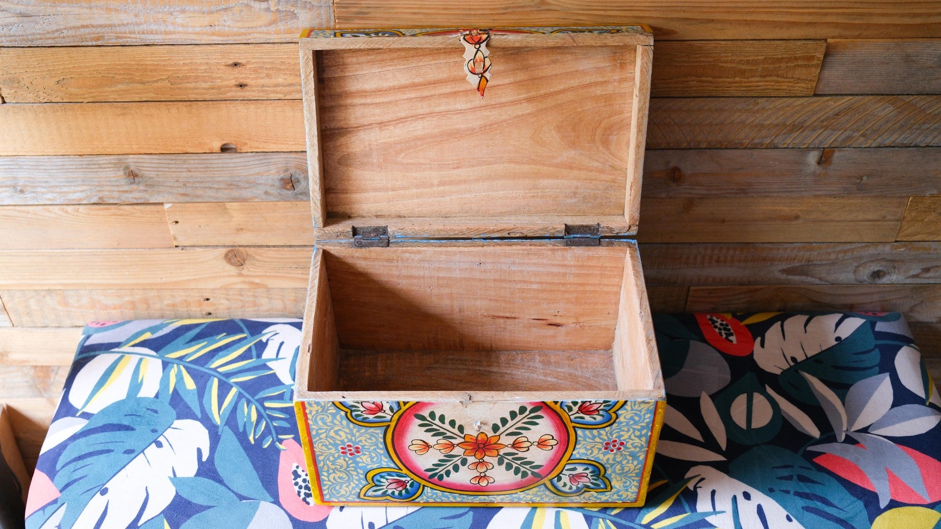 Wooden box with colorful design on a wooden surface