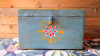 Wooden box with floral design on a wooden surface