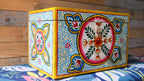 Decorative box with colorful floral patterns on a wooden surface