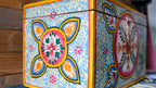 Decorative box with colorful floral patterns on a wooden surface