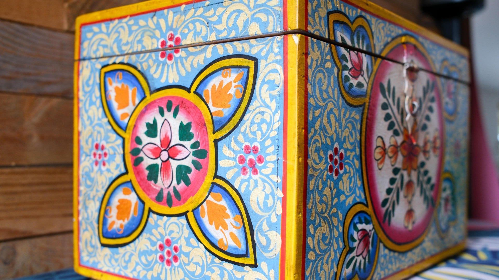 Decorative box with colorful floral patterns on a wooden surface
