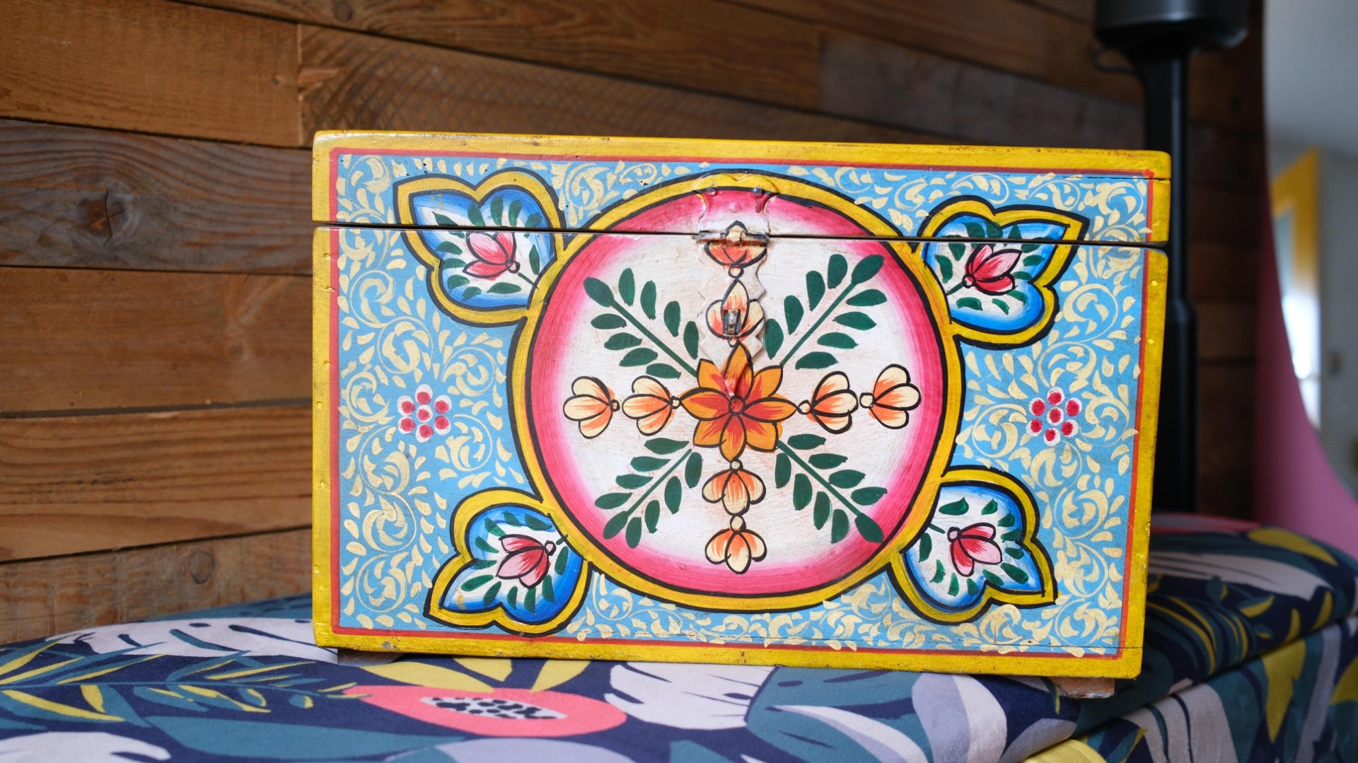 Decorative box with floral patterns on a colorful fabric background