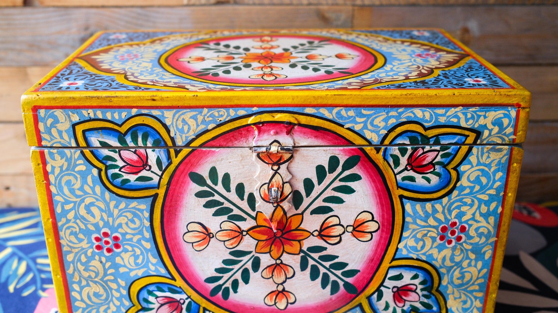 Colorful hexagonal box with floral patterns on a wooden surface