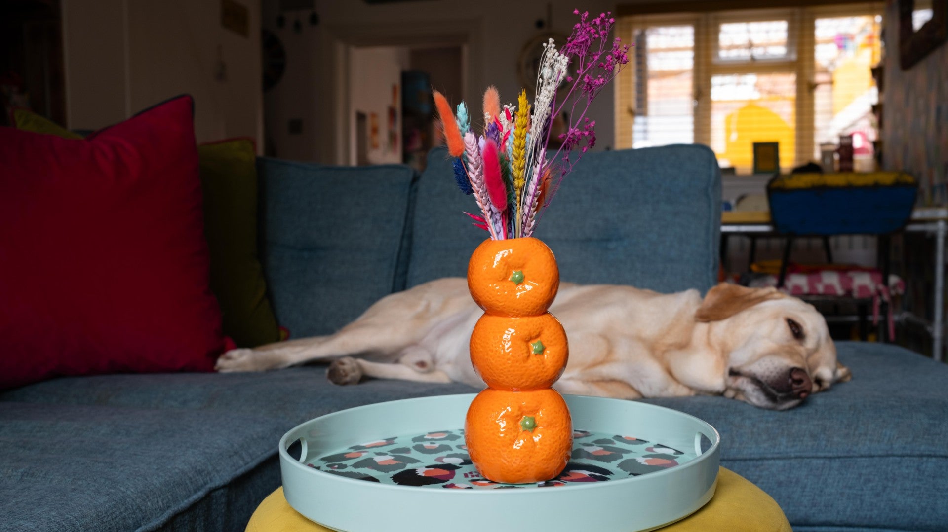 Orange decorative vase with colourful flowers 
