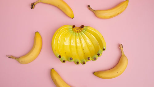 Yellow banana-shaped object on a pink background