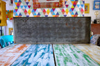 Metal box on a table with colorful geometric patterned wall in the background
