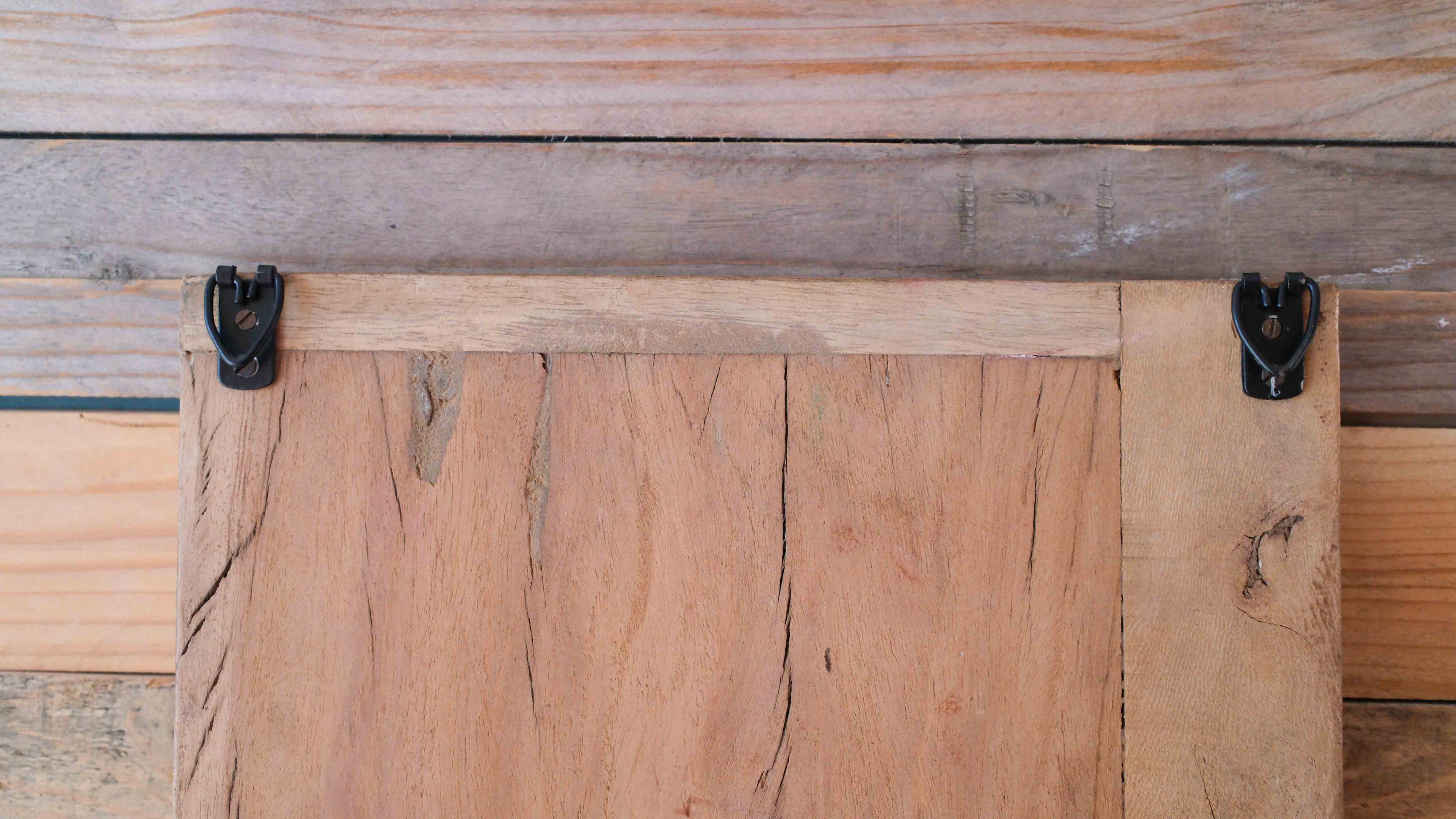 Wooden panel with metal brackets on a wooden background