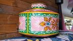 Decorative metal pot with floral patterns on a wooden surface