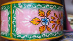 Decorative container with floral patterns on a pink background
