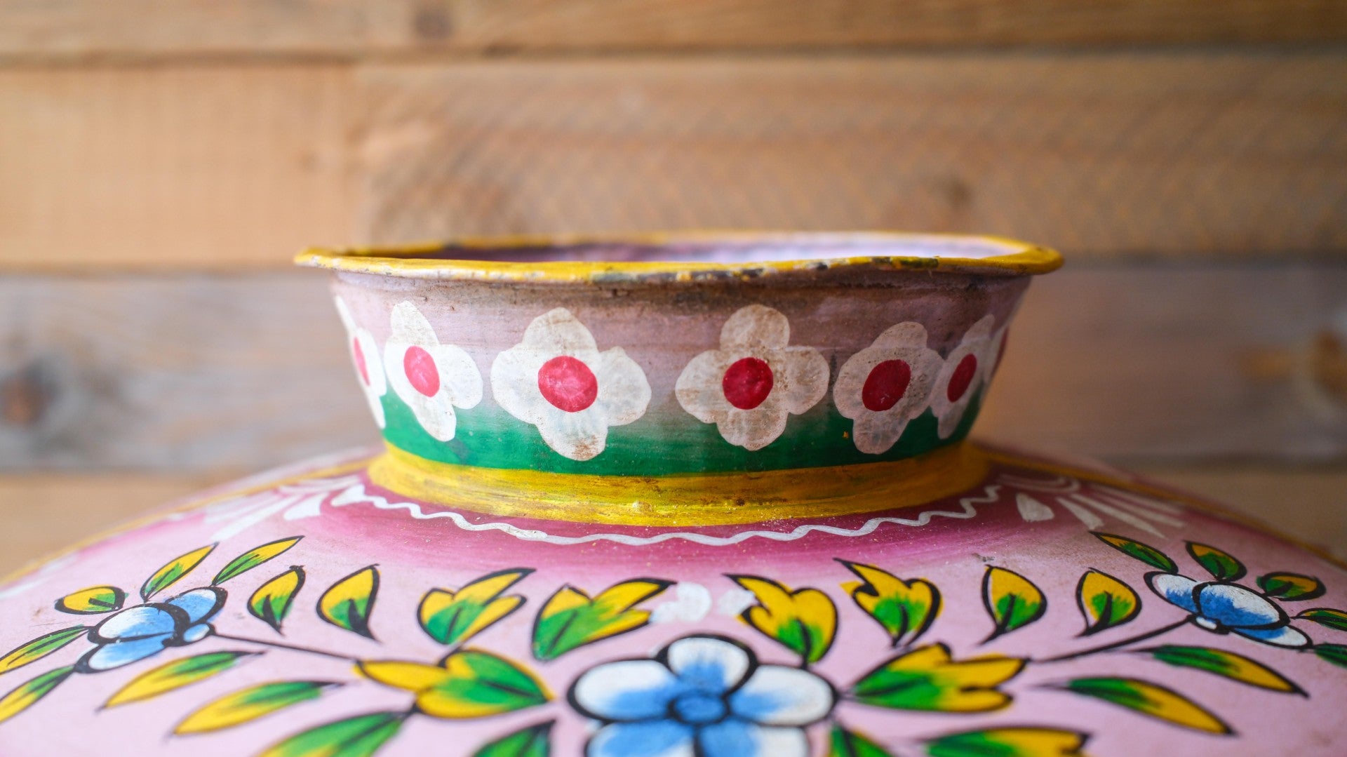 Decorative metal pot pot with floral patterns on a wooden surface
