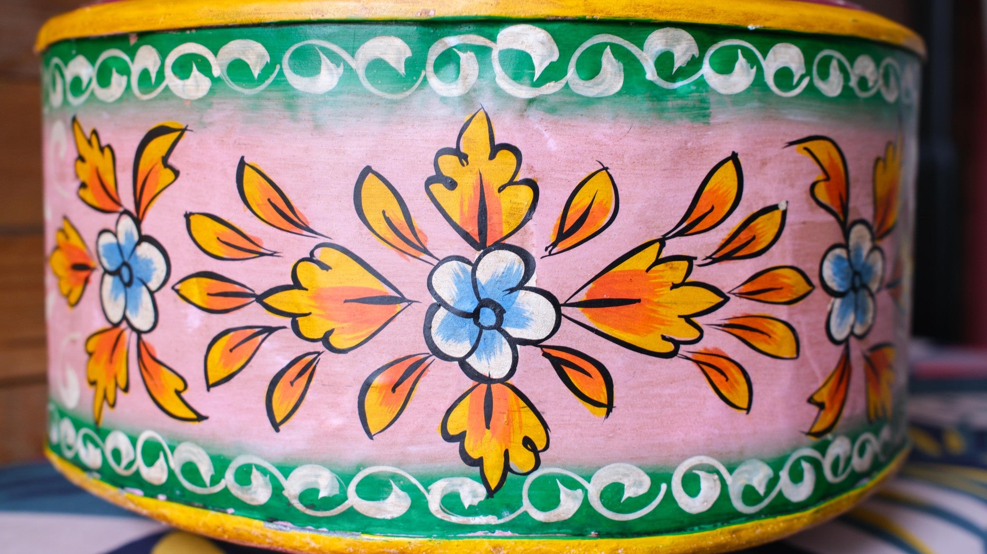 Decorative metal bowl with floral patterns on a pink background