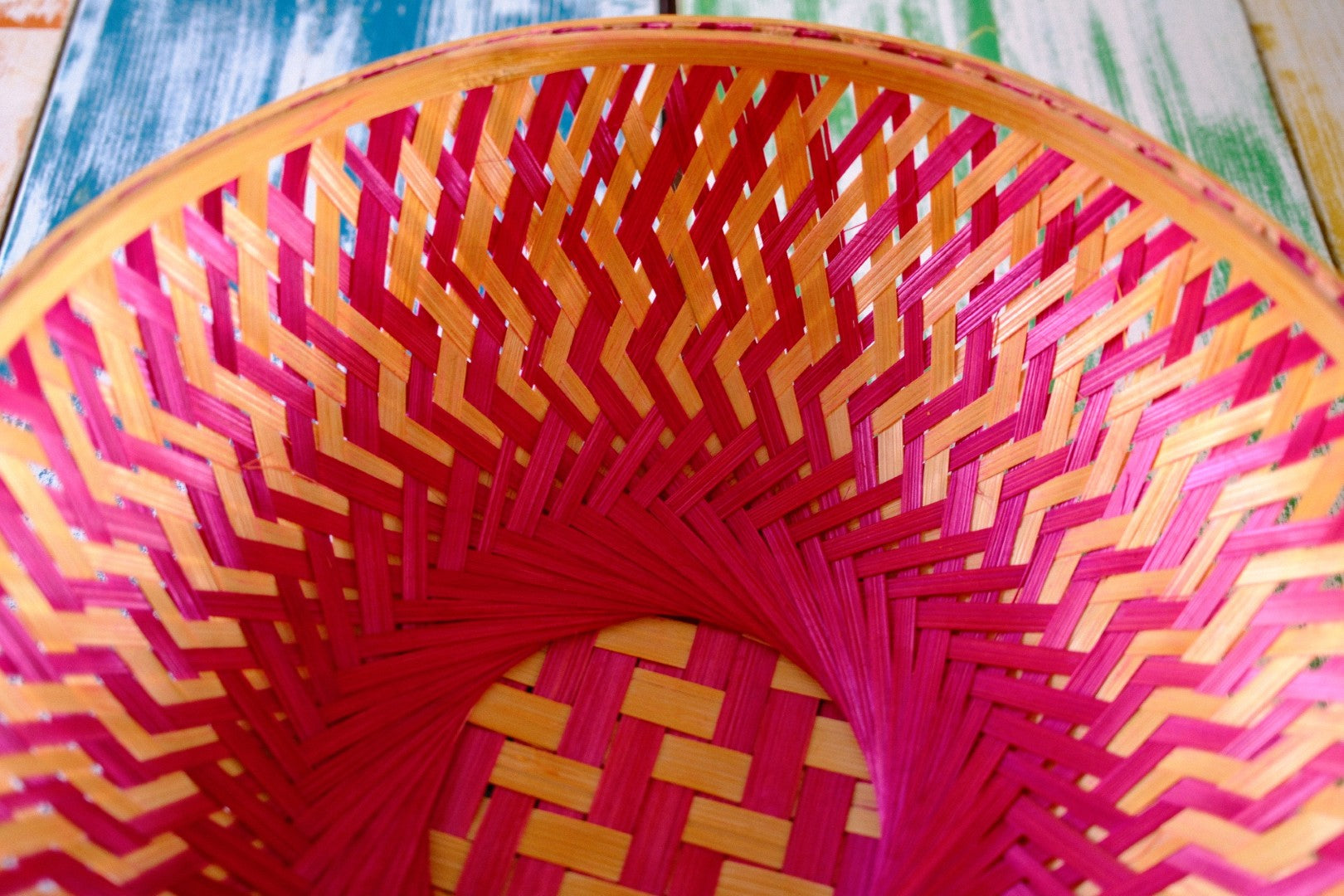 Close-up of a colorful woven basket with pink pattern.