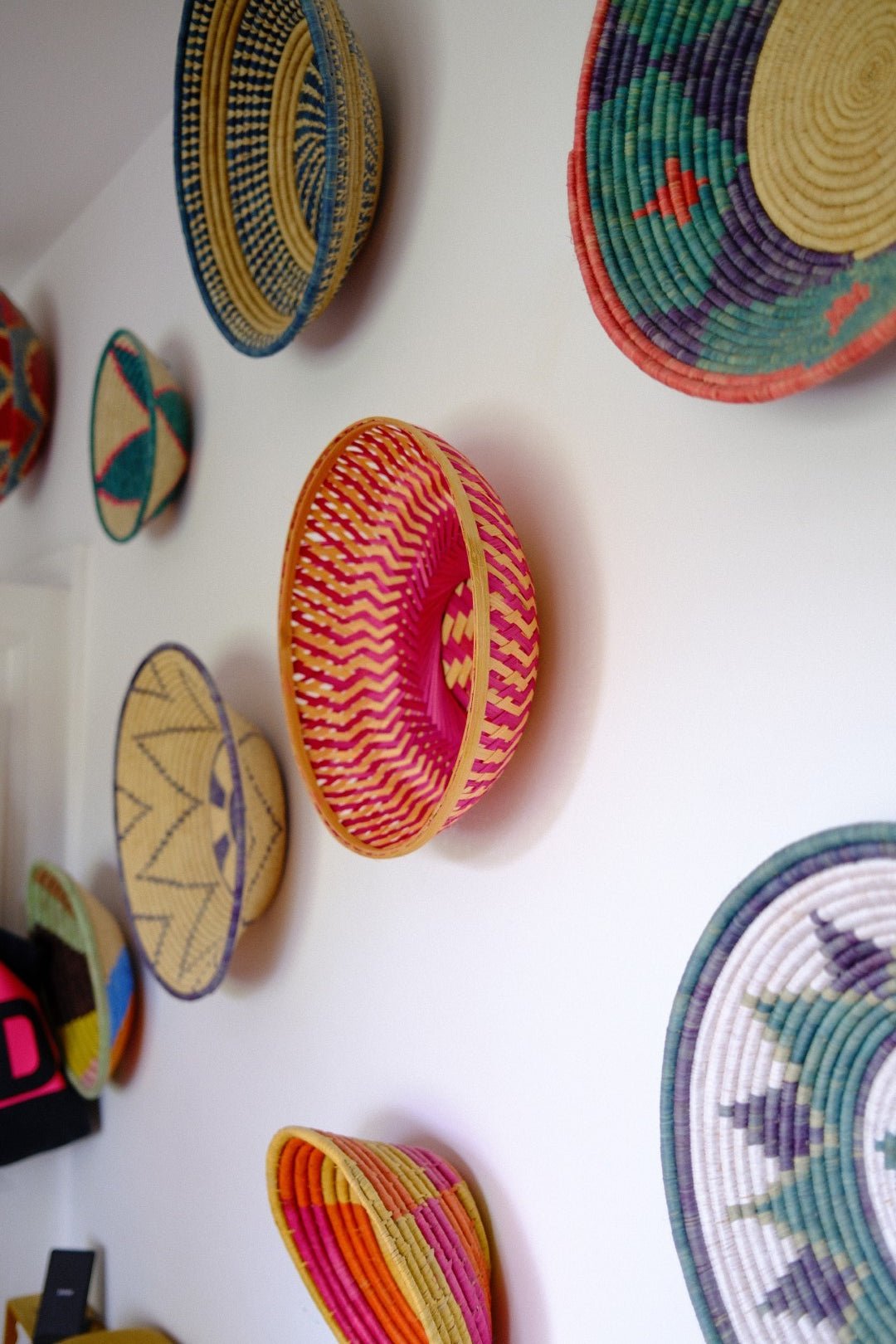 Colorful woven bowls on a white surface