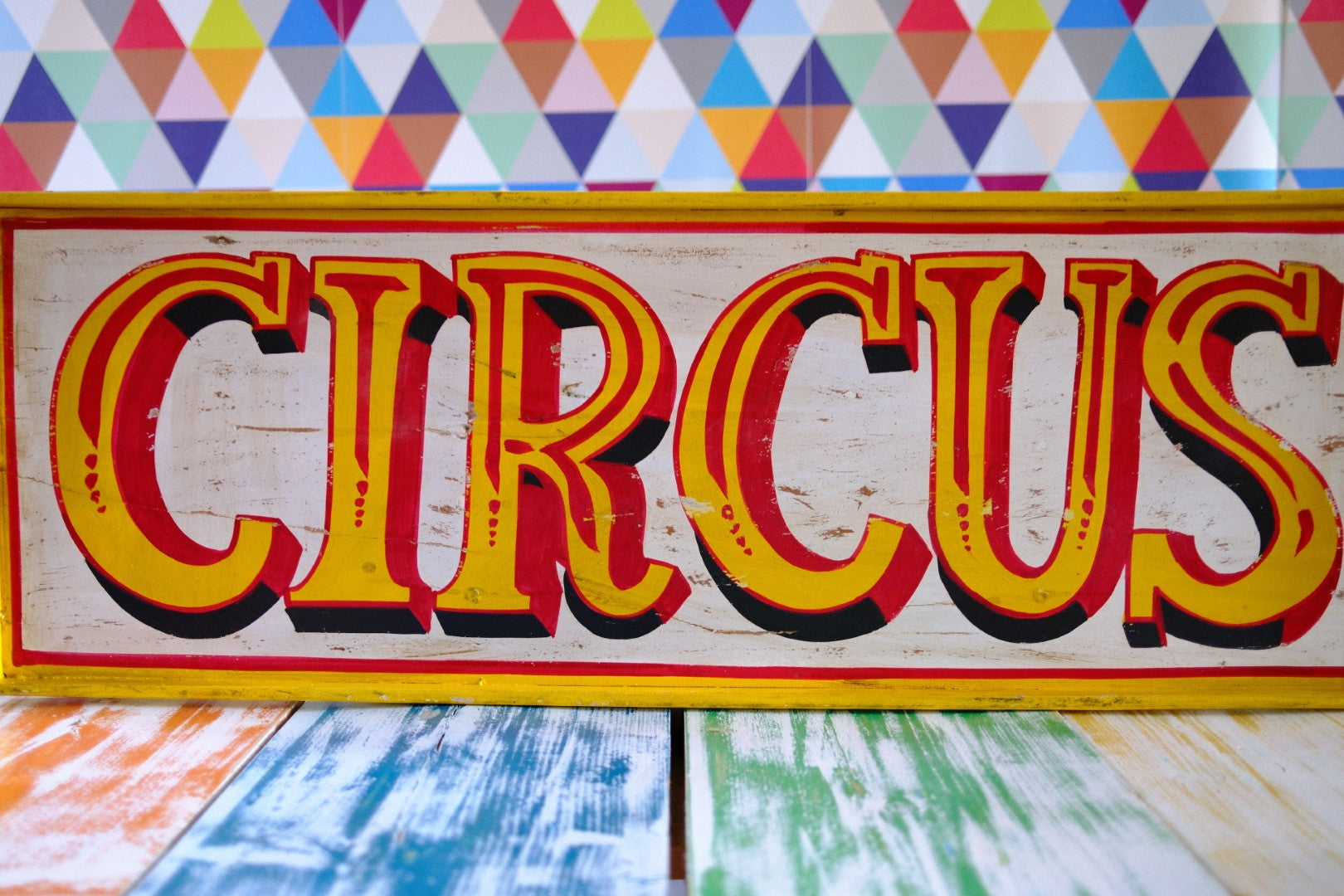 Vintage-style 'Circus' sign with colorful geometric pattern above