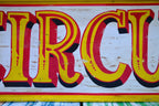 Vintage-style 'Circus' sign with yellow and red text on a white background