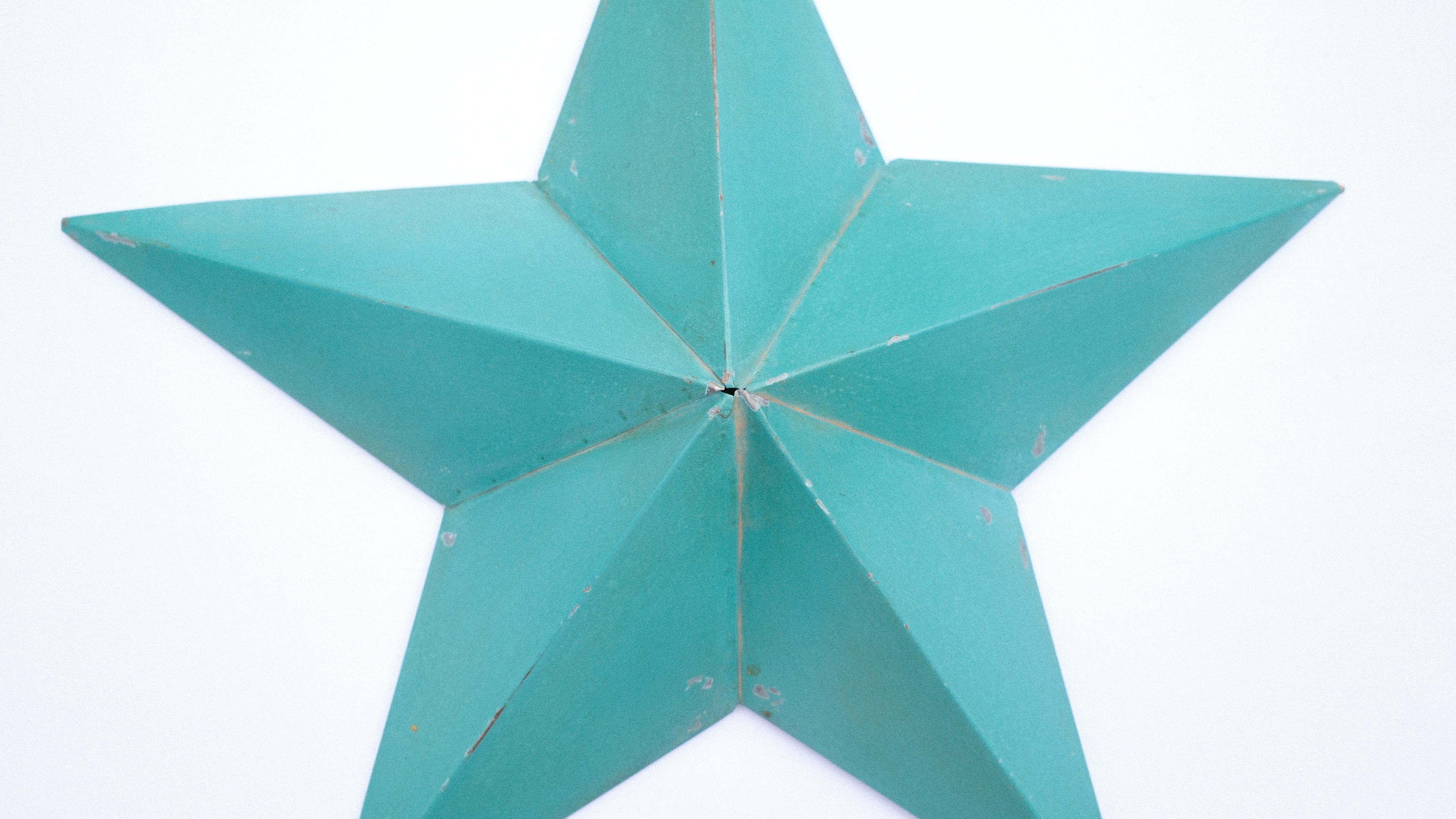 Turquoise rustic barn star-shaped decorative item on a white background