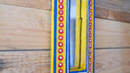 Colorful belt with red and yellow pattern on a wooden surface