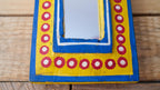 Decorative mirror with a colorful frame on a wooden surface