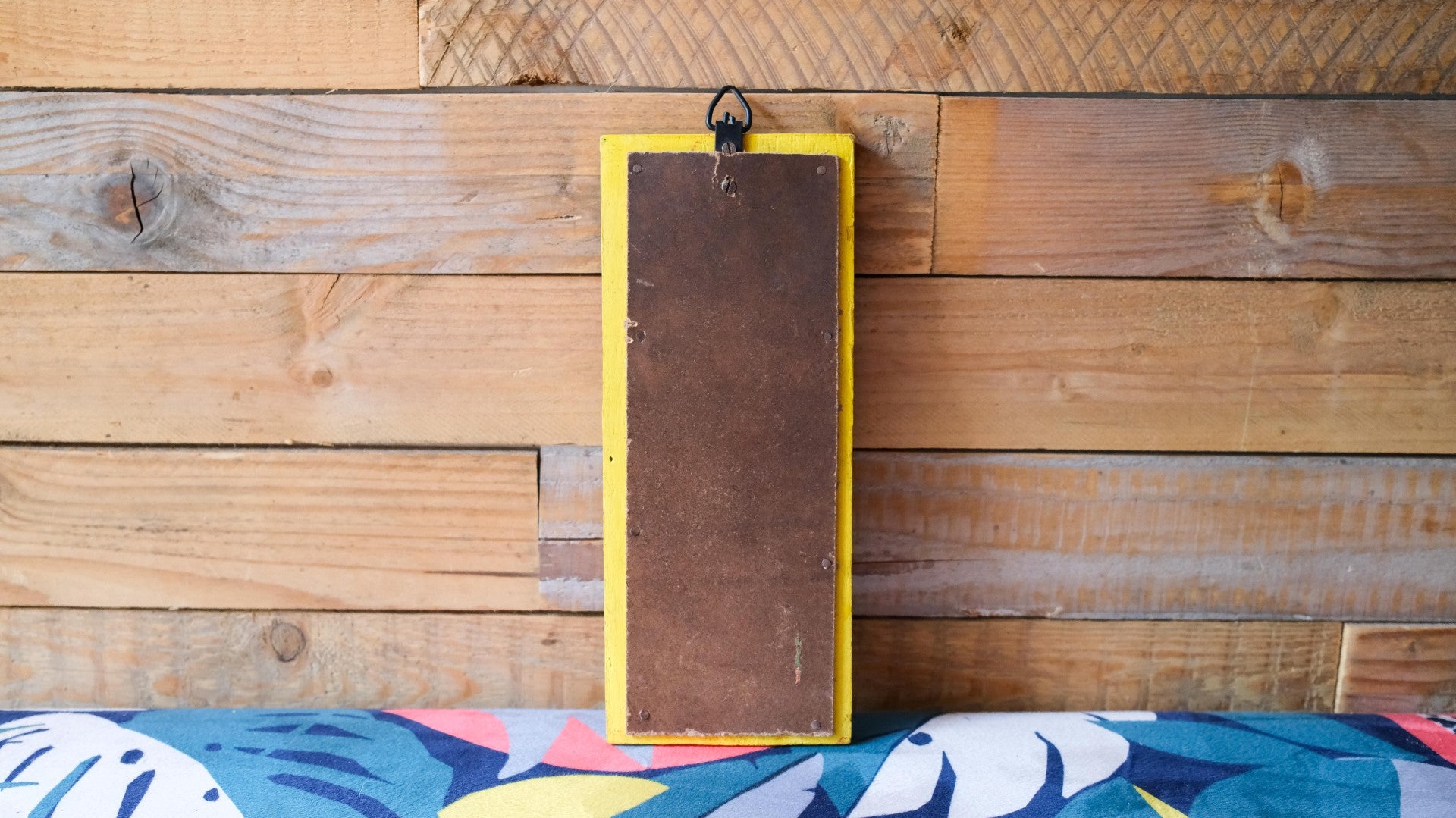 Rectangular brown object with yellow border on a wooden surface