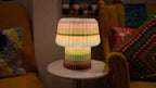 Colorful lamp on a small round table with a cozy living room background