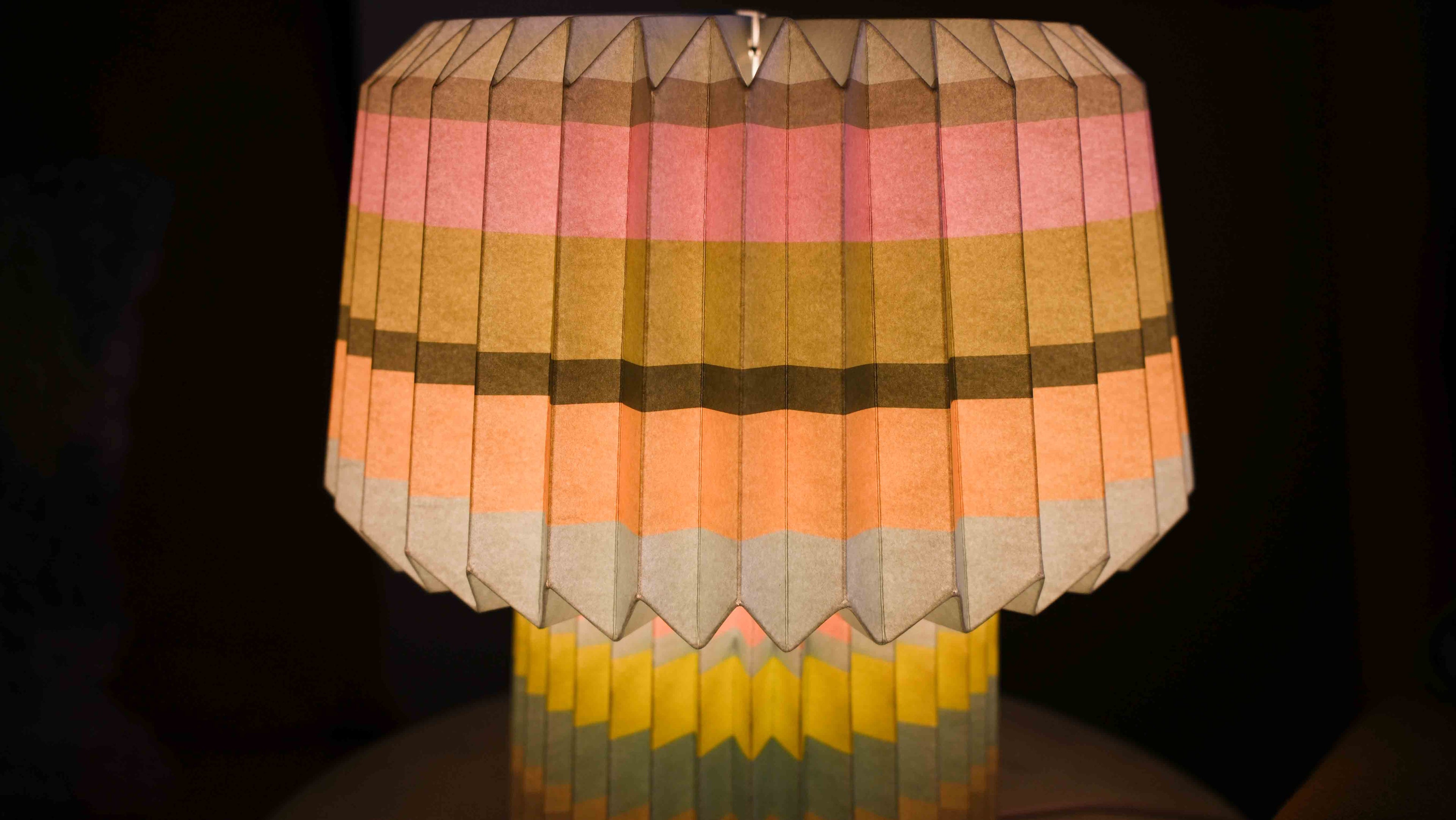Colorful folded paper lamp on a dark background