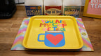 Yellow tray with 'You Are My Cup of Tea' design on a wooden surface with tea products in the background.