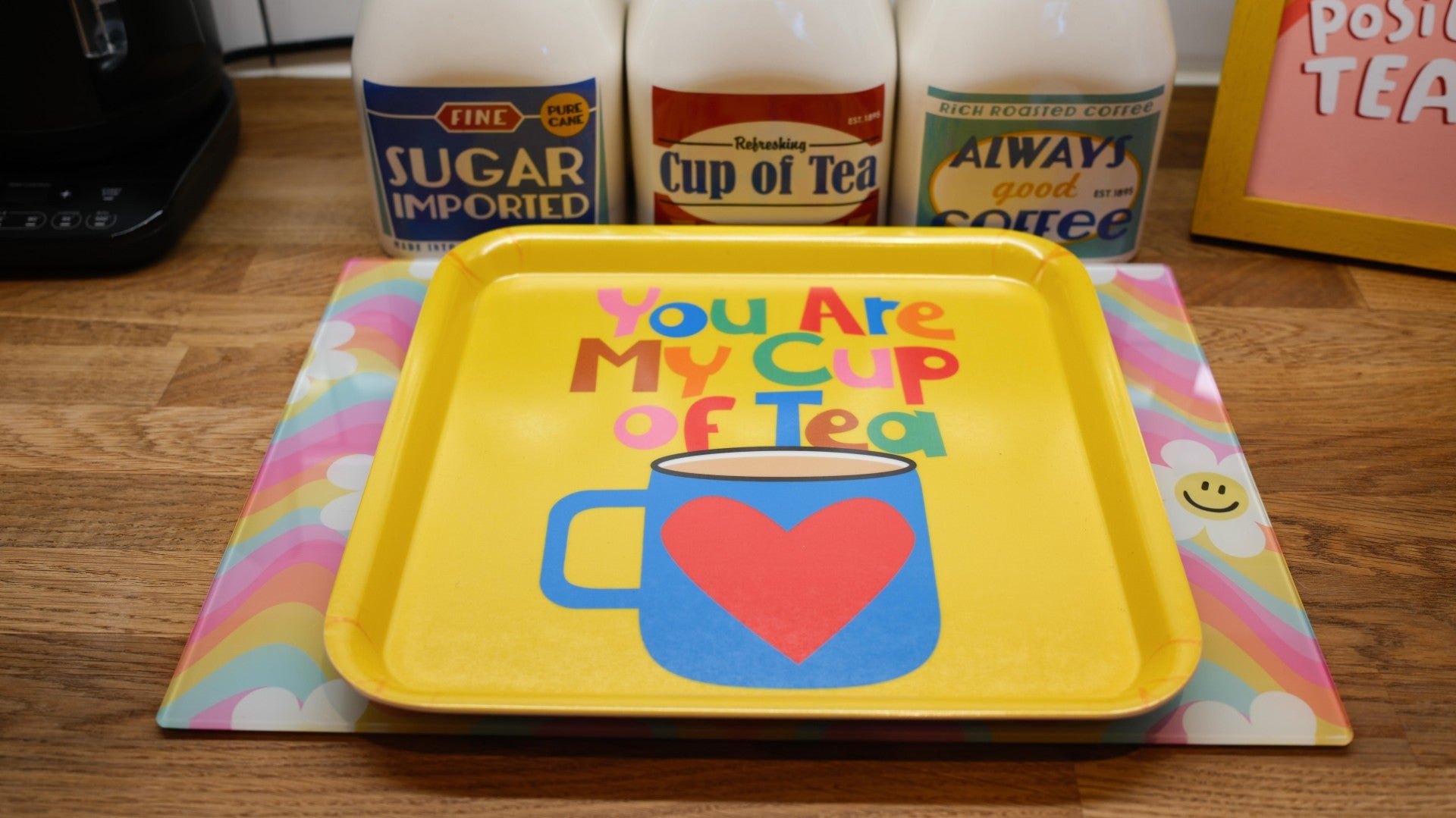 Yellow tray with 'You Are My Cup of Tea' design on a wooden surface with tea products in the background.