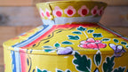 Colorful metal pot with floral patterns on a wooden surface