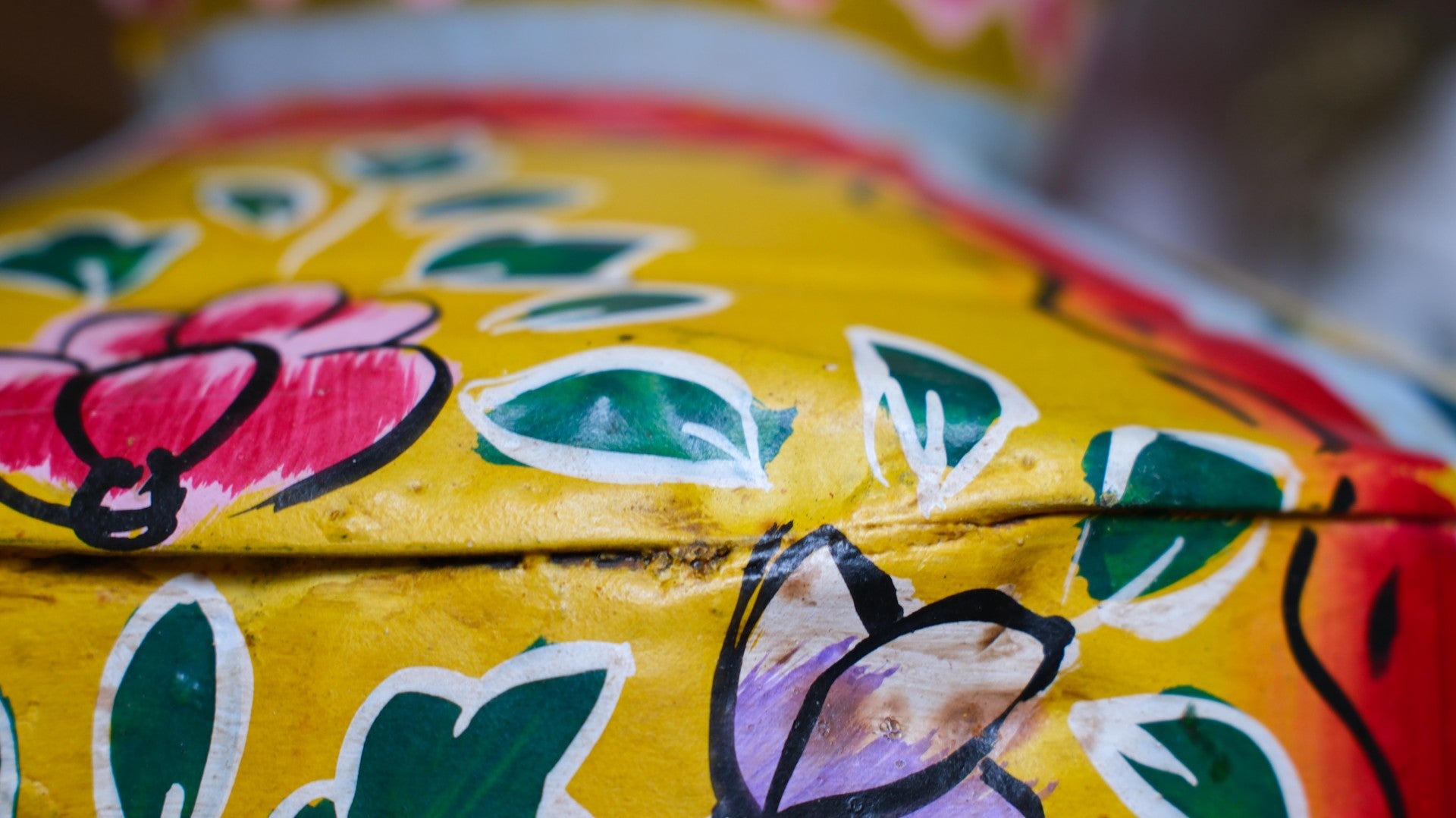 Close-up of a colorful hand-painted pot with floral designs.